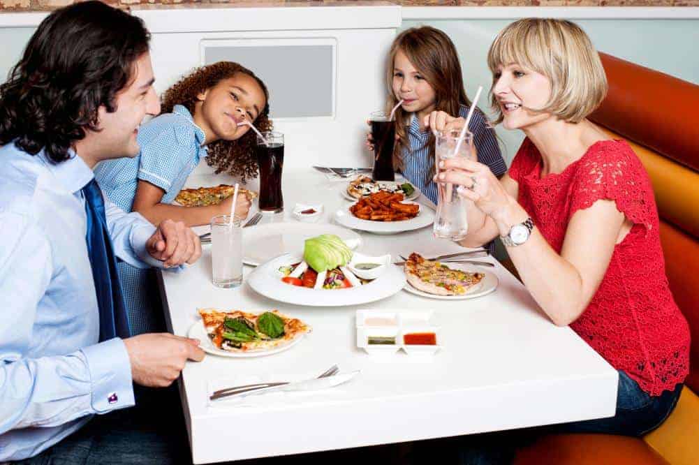multi ethnic family eating together at a diner